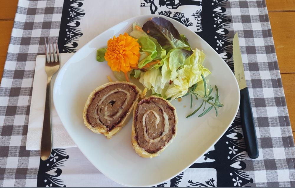"Filet paysan Natura-Beef" servi avec une salade verte et une fleur comestible.