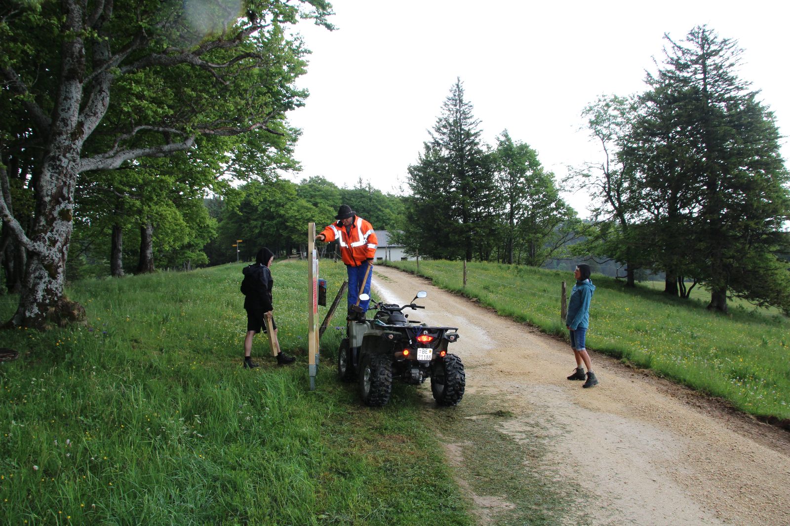 John Haldemann se tient debout sur un quad avec un gros marteau pour enfoncer un poteau de jeu.